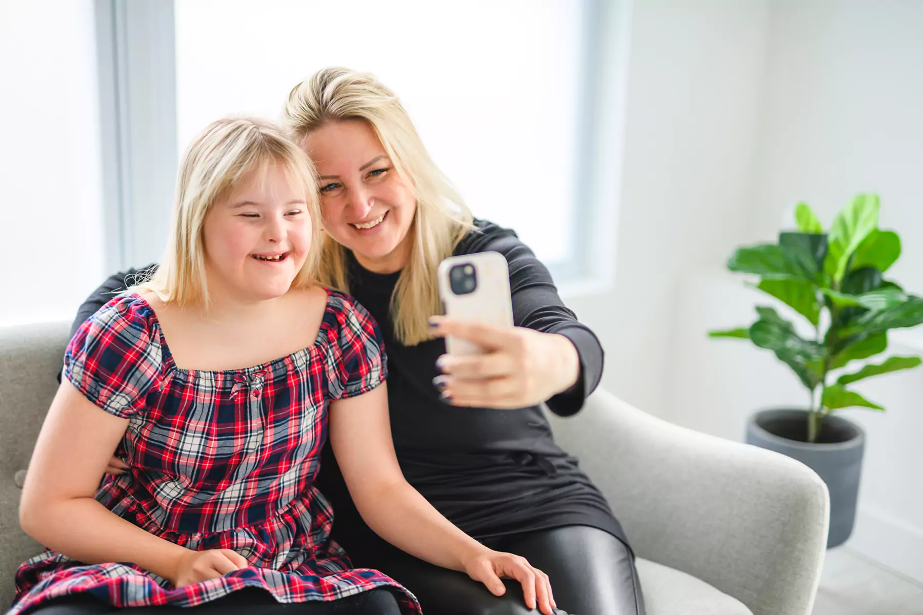 A disabled girl and her mother smiling while taking a selfie